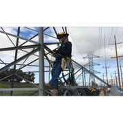 Person working on a metal structure with power lines and towers in the background