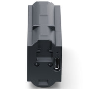 A dark gray rectangular electronic device with a USB-C port on the side, shown from a top-down angle on a white background.