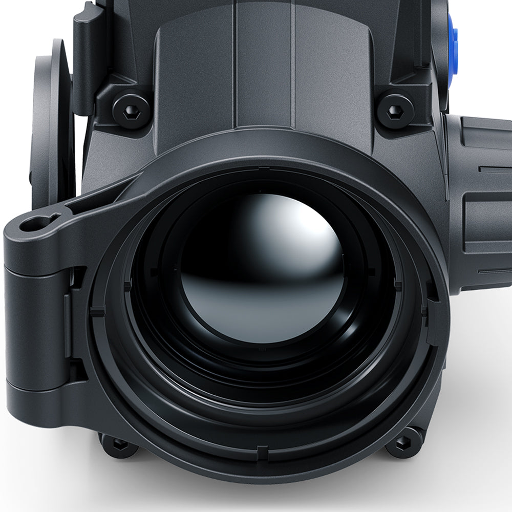 Close-up of a black thermal imaging scope or camera lens housing with a large objective lens, shown on a light gray background.
