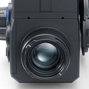 Close-up of a dark gray industrial camera or projector lens assembly with a large circular lens element and metallic ring details.