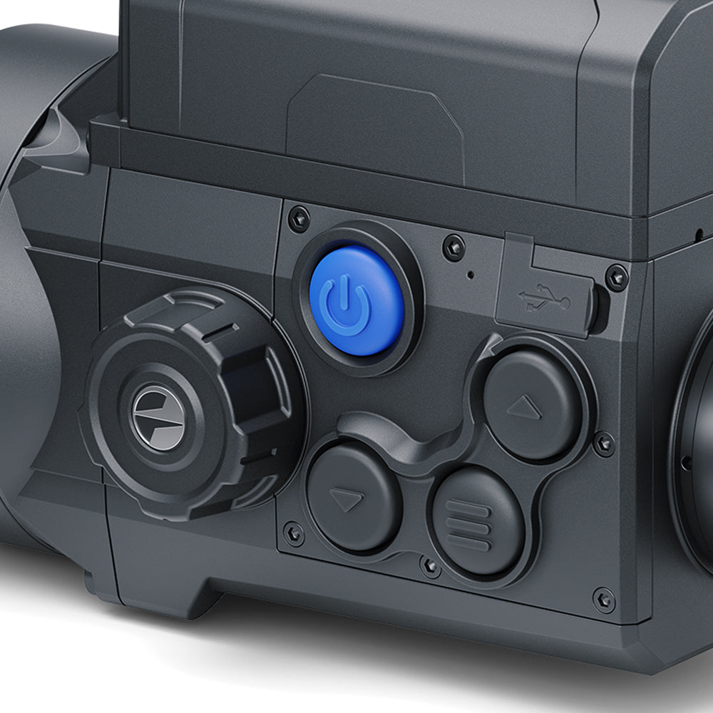 Close-up of a dark gray electronic device control panel with a prominent blue power button and textured black dials.