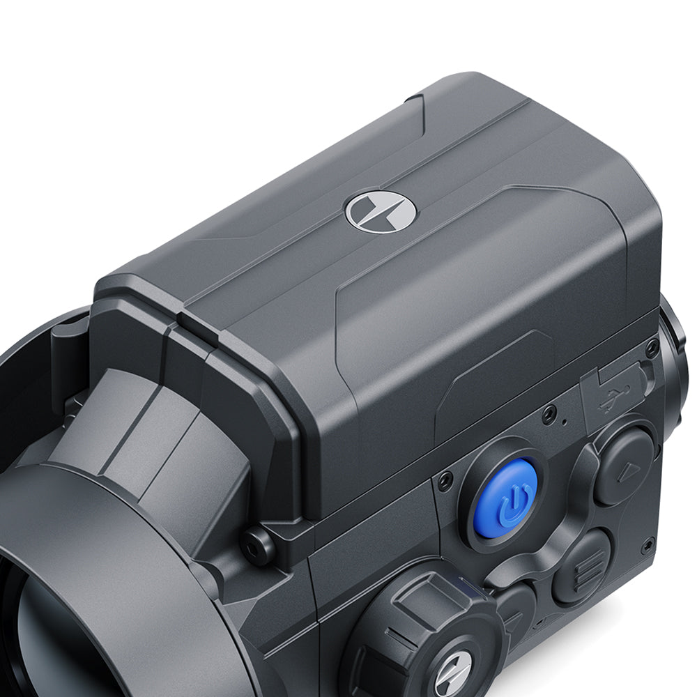 Close-up of a black tactical device, likely a camera or electronic accessory, featuring a matte black finish, a blue power button, and a silver logo on top, set against a plain white background.