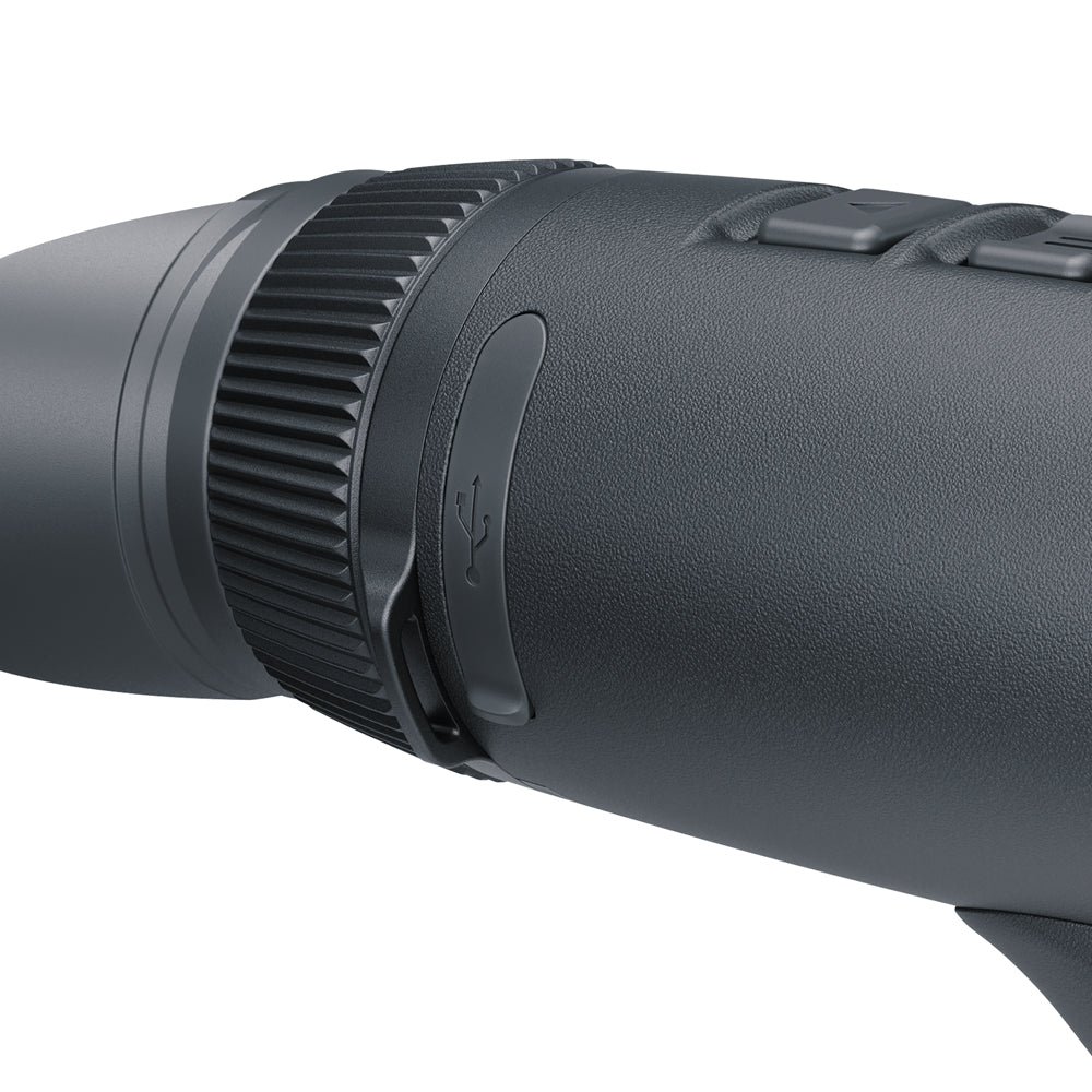 Close-up of a black textured monocular eyepiece focusing ring with a central button, on a solid white background.