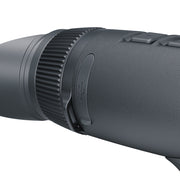Close-up of a dark gray textured monocular or binocular eyepiece with a ribbed focusing ring and side buttons, shown against a plain white background.