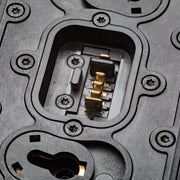Close-up of a black molded plastic electronic component with gold-plated contacts inside a recessed slot.