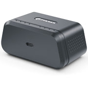 A dark gray rectangular electronic device with rounded corners, featuring a USB-C port on the side and a logo on top, photographed on a white background.