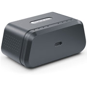 A dark gray rectangular electronic device with rounded corners, featuring a USB-C port on the front, a speaker grille on the side, and a small logo plate on top, shown on a white background.