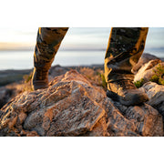 Camouflage pants and Nano X1 Adventure Tactical boots on a rocky landscape