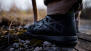 Black Reebok Nano Tactical Boot on a wooden platform with a blurred natural background