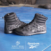 Black Reebok Nano Tactical Boots on a blue surface with Reebok and Navy SEAL Foundation logos