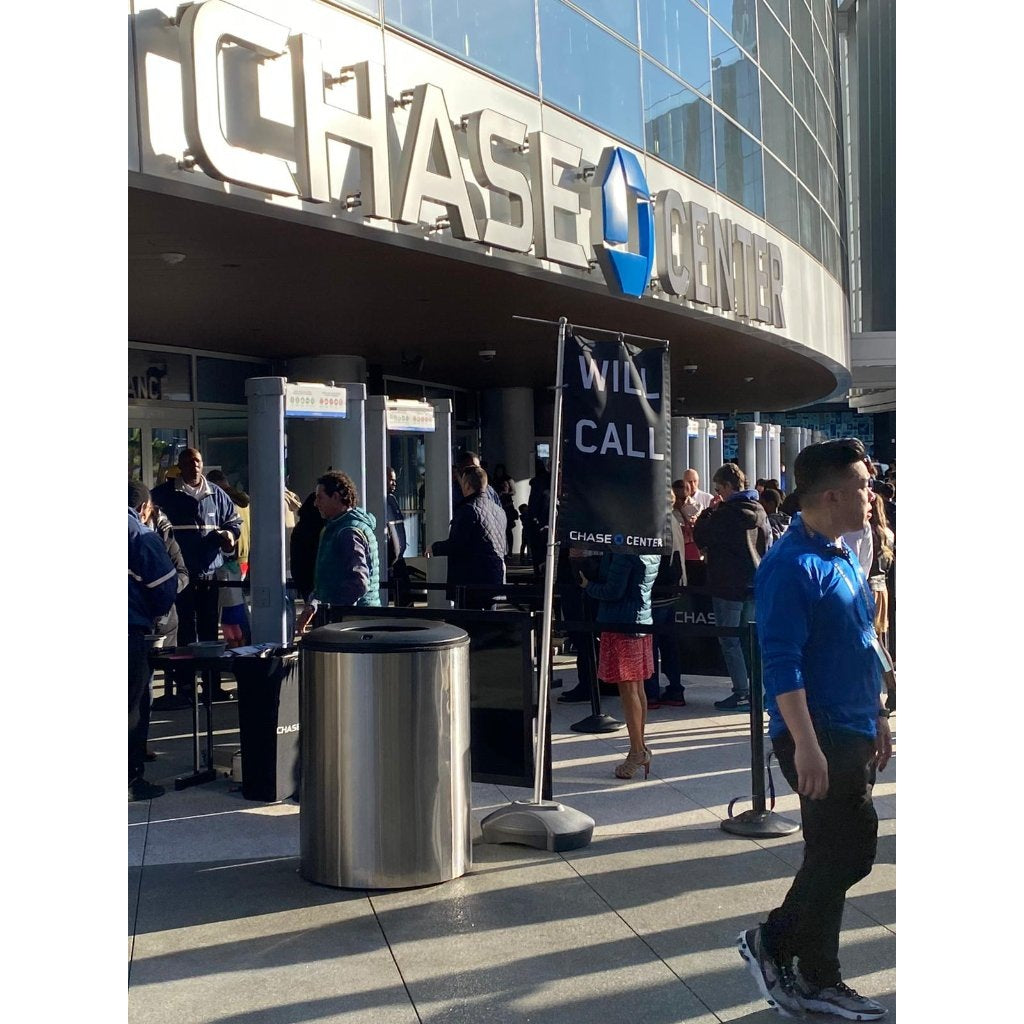Blast containment receptacle at arena security screening checkpoint with metal detectors